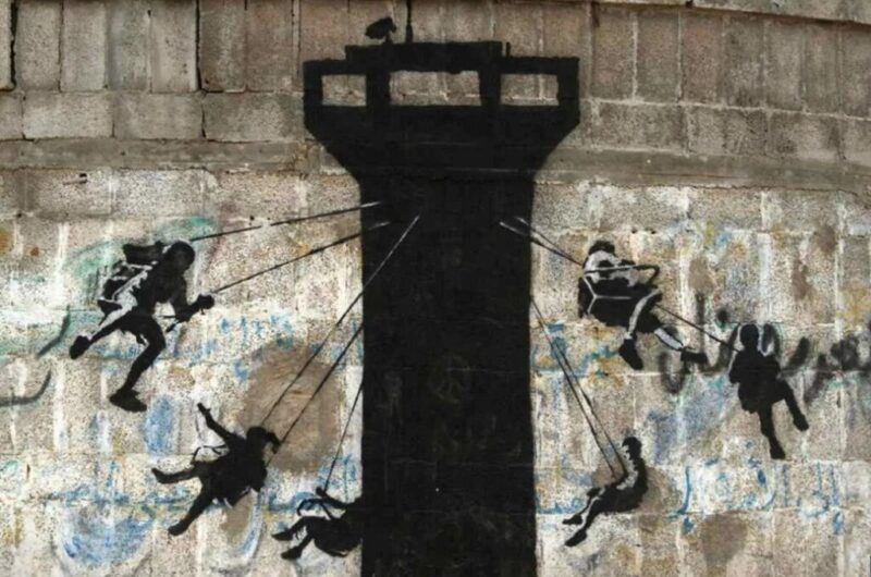Un murale raffigurante bambini che usano una torre di guardia dell’esercito israeliano come giostra, dipinto dall’artista britannico Banksy, visibile su un muro lungo la strada principale di Beit Lahiya, nella Striscia di Gaza settentrionale, il 17 febbraio 2015. Foto: Adel Hana
